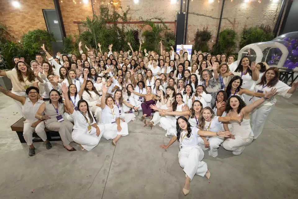 Participantes da 5ª edição do MulherEHS, todas de branco, acenando para a câmera
