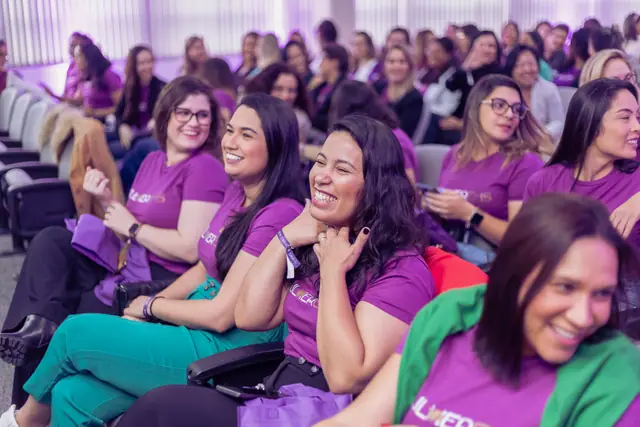 Participantes sorrindo e conversando na plateia
