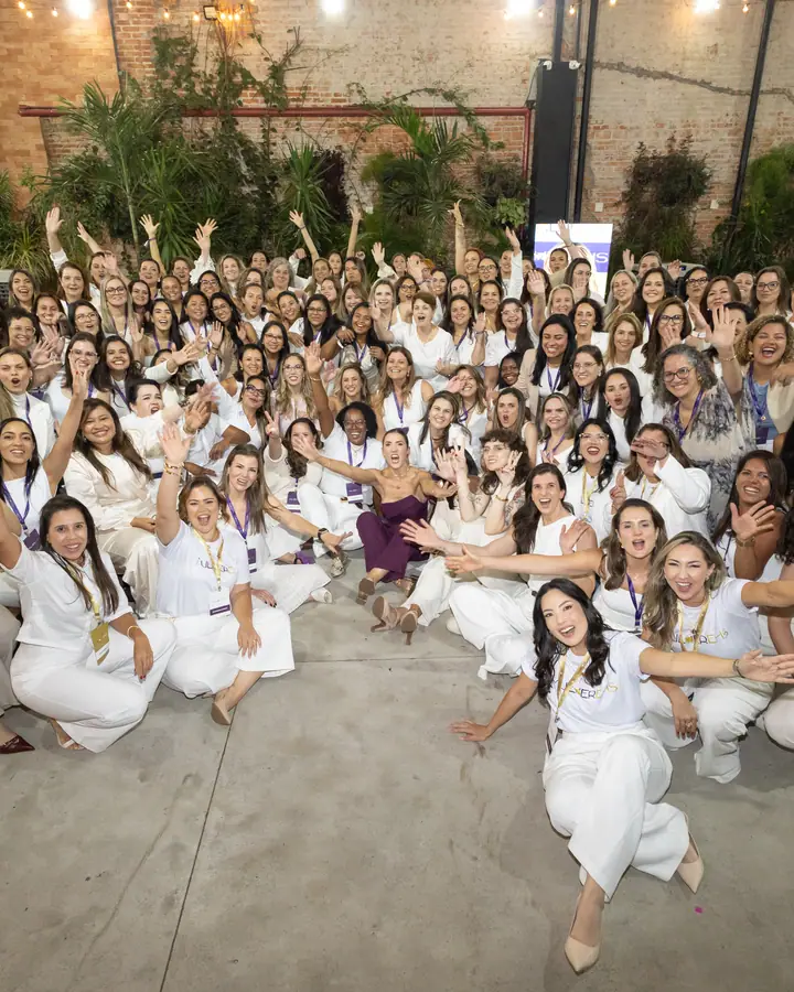 Participantes da 5ª edição do MulherEHS, todas de branco, acenando para a câmera